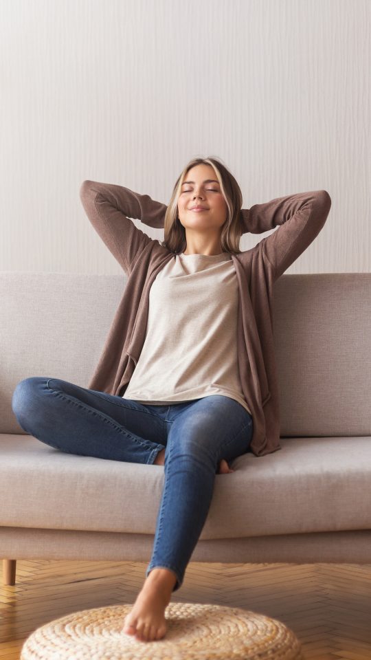 a woman is sitting on a couch and relaxing at The Woodview