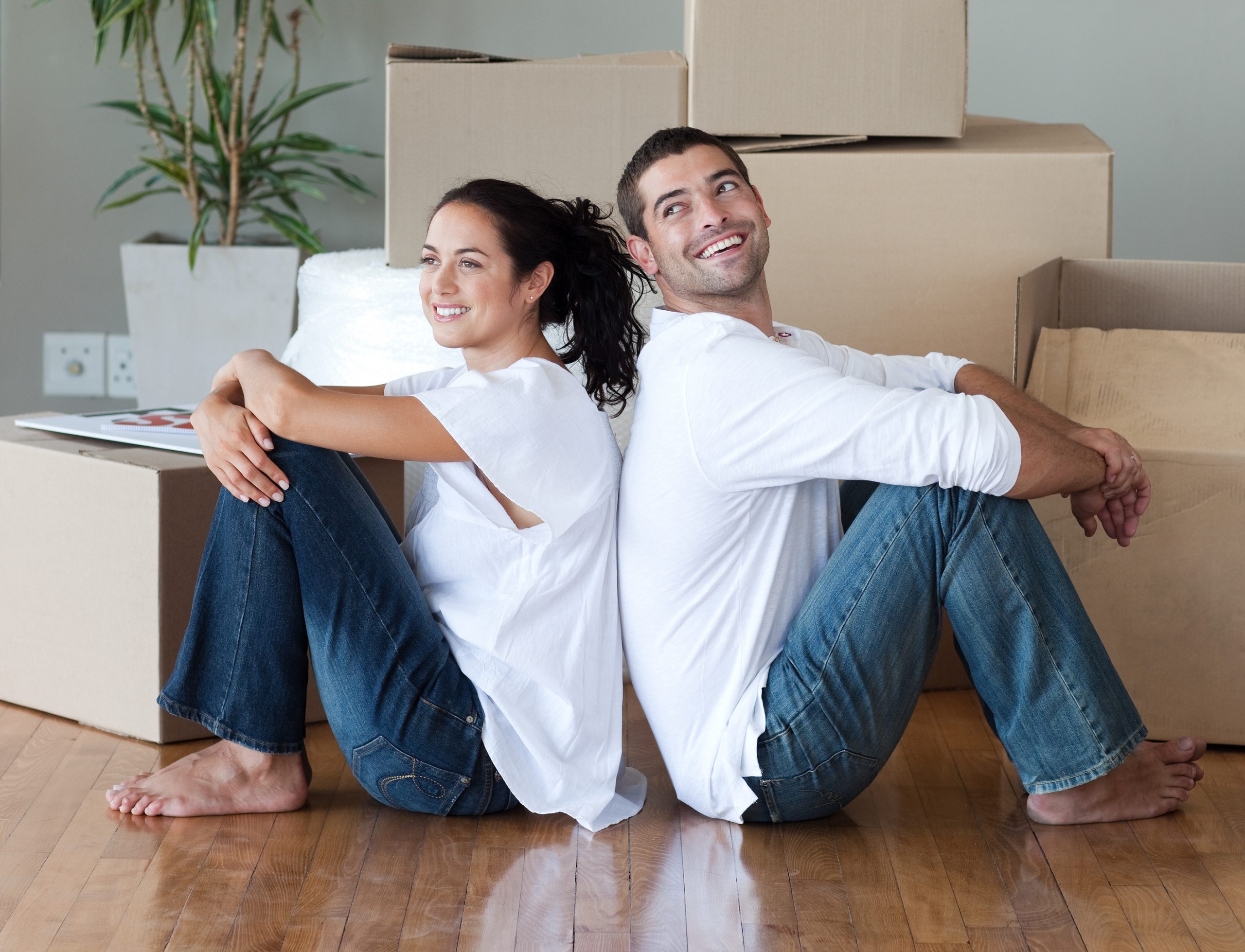 a couple sitting on the floor in front of boxes at The Woodview